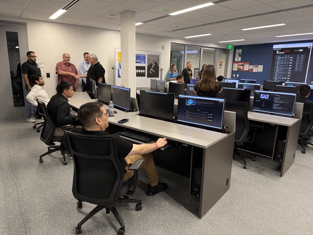 Students are in the Security Operations Center playing Cyber Assistant to Capture the Flag during Cybersecurity Day.